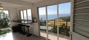 a room with large windows and a view of the ocean at Les Jardins Suspendus de la Caraïbe in Le Carbet