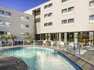 a swimming pool in front of a building at Mercure Agen Centre in Agen