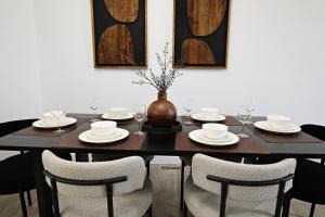 une table de salle à manger avec des chaises et un vase dessus dans l'établissement Kinglet 4BR Getaway AC Garage Near WEM DisneyPlus, à Edmonton 70 autres photos