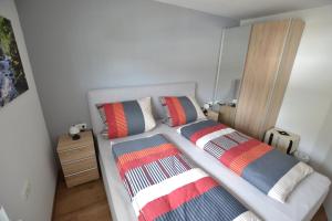 a bedroom with two beds with colorful pillows on it at Wohnen bei Gerlis in Burbach