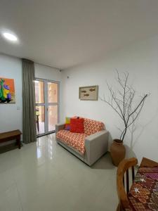 ein Wohnzimmer mit einer Couch in einem Zimmer in der Unterkunft Apartamento com jardim em condomínio resort in Parnamirim