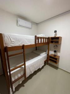 zwei Etagenbetten in einem Zimmer mit einer Lampe in der Unterkunft Apartamento com jardim em condomínio resort in Parnamirim + 26 Fotos