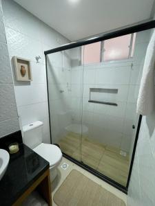ein Badezimmer mit Dusche, Toilette und Waschbecken in der Unterkunft Apartamento com jardim em condomínio resort in Parnamirim