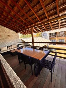 una mesa de madera y sillas en un patio al aire libre en Reserva Flamboyant, en Barra Grande