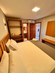 Un dormitorio con una cama grande y un baño. en Reserva Flamboyant, en Barra Grande 170 fotos más