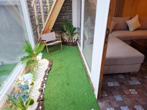 a small balcony with green grass on the floor at Rooftop terasse azur essaouira in Essaouira