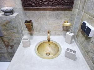 a bathroom with a gold sink in a room at rooftop studio essaouira in Essaouira +28 photos