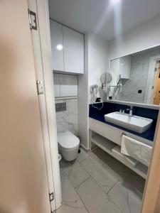 a bathroom with a white toilet and a sink at Sunny Sea View Aparthotel in Orbi City Batumi in Batumi +89 photos
