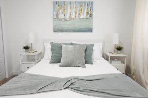 une chambre avec un lit avec des draps blancs et des oreillers dans l'établissement Kinglet 4BR Getaway AC Garage Near WEM DisneyPlus, à Edmonton