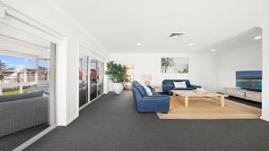 a living room with a blue couch and a table at Hibbard Waterfront Escape in Port Macquarie