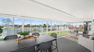 a living room with a table and chairs at Hibbard Waterfront Escape in Port Macquarie