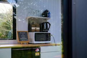 a microwave sitting on a counter next to a window at Ryan's Ranch by Tiny Away in Belgrove