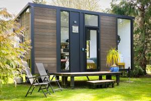a tiny house with a picnic table and chairs at Ryan's Ranch by Tiny Away in Belgrove