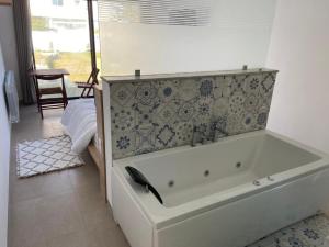 a white bath tub in a bathroom with a wall at Dar Aissa in El Maamoura +31 photos