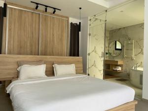 a bedroom with a large white bed and a bathroom at Dar Aissa in El Maamoura