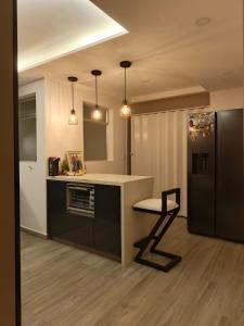 cocina con encimera y nevera negra en Penthouse with Jacuzzi in Guarne, en Guarne