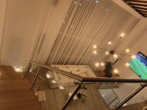 a living room with a staircase with a couch and a television at Penthouse with Jacuzzi in Guarne in Guarne