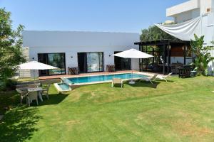 a backyard with a swimming pool and a house at Dar Aissa in El Maamoura