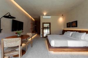 1 dormitorio con cama y mesa con mesa en Evva Pousada - Soft Opening, en Porto de Pedras