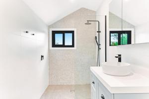 a white bathroom with a sink and a shower at Homestead on Fennell - Fresh Eggs, Farm & BBQ Fun in Toronto +19 photos