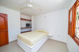 ein Schlafzimmer mit einem Bett und einem Deckenventilator in der Unterkunft Apartamentos Mafelo Taganga in Taganga