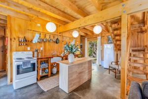 a kitchen with wooden walls and wooden ceiling at The Gatehouse - Tata Headlands in Tata Beach