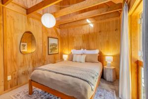 a bedroom with a bed in a wooden room at The Gatehouse - Tata Headlands in Tata Beach