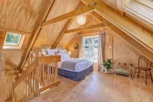 a bedroom with a bed in a room with wooden walls at The Gatehouse - Tata Headlands in Tata Beach +4 photos