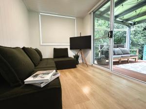 Una sala de estar con un sofá y un televisor. en Atherton Tiny - Retreat with Fire Pit, en Atherton 24 fotos más