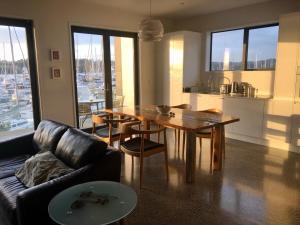 a living room with a wooden table and a couch at Luxury Waterfront Marina Apartment - Bay of Islands, New Zealand in Opua
