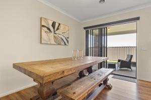 a dining room with a wooden table and a bench at Family Retreat with Garden and Parking in Melbourne