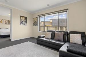 a living room with a black couch and a window at Family Retreat with Garden and Parking in Melbourne +12 photos