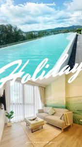 a living room with a view of a swimming pool at BangTao Rooftop Seaview Laguna Skypark Condominium in Laguna Phuket