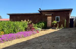 une maison avec des fleurs violettes devant dans l'établissement Casa-jardín Luz de Botellas -piscina-jacuzzi-sauna, 