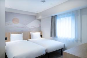 a hotel room with two beds and a window at Garner Hotel Kyoto Shijo Karasuma by IHG in Kyoto +29 photos