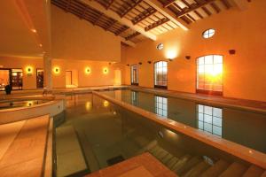 a large indoor swimming pool in a building at Holiday flats at Domaine de Saint-Endréol with golf, SPA and pool in La Motte