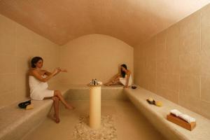two women sitting in a tub in a bathroom at Holiday flats at Domaine de Saint-Endréol with golf, SPA and pool in La Motte