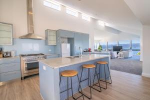 een keuken met een wastafel en een aanrecht met krukken bij Seaview Home in Khandallah in Wellington +32 foto's