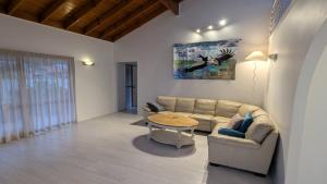 una sala de estar con un sofá y una mesa en Flamingo Sunset Retreat, en Old Bribie