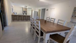 Un comedor y una cocina con mesa y sillas de madera. en Flamingo Sunset Retreat, en Old Bribie 15 fotos más