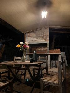 Una mesa de madera con un jarrón de flores encima. en Brotó de fuego, en Sauce de Portezuelo