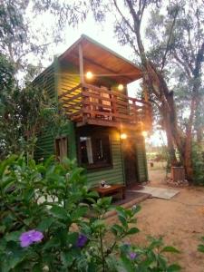 Una pequeña casa en el árbol verde con terraza. en Brotó de fuego, en Sauce de Portezuelo