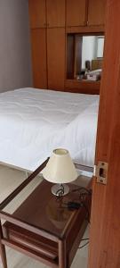 a lamp on a glass table next to a bed at Sara's House in Minas +4 photos