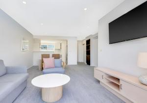 una sala de estar con un sofá y una mesa en One-Bedroom Lagoon Spa Apartment, en Salamander Bay