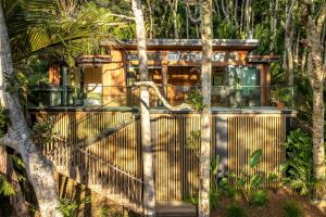 a wooden fence with a gate in a forest at Te Toki Treehouse and Studio in Waiheke Island
