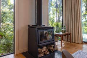 a fireplace in a living room with a television at Te Toki Treehouse and Studio in Waiheke Island