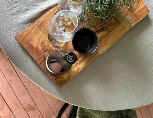 a wooden table with glasses and wine bottles on it at Atherton Tiny - Retreat with Fire Pit in Atherton