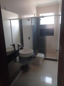 a bathroom with a toilet and a sink and a shower at Casa Freire in Lavras