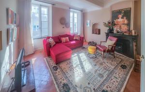 a living room with a red couch and a fireplace at Nice Home In Saint-Chinian With Wifi in Saint-Chinian