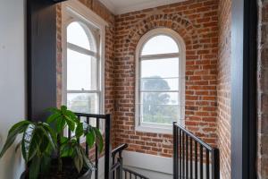 un couloir en briques avec deux fenêtres et une plante dans l'établissement Annie May- Devonport, à Devonport